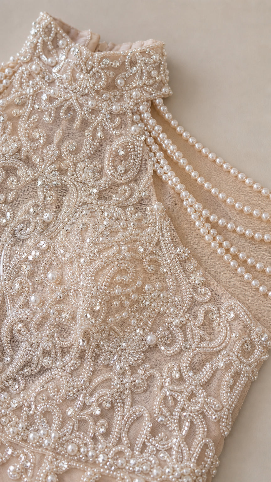 Close-up detail of intricate bead embroidery and draped pearls on neckline