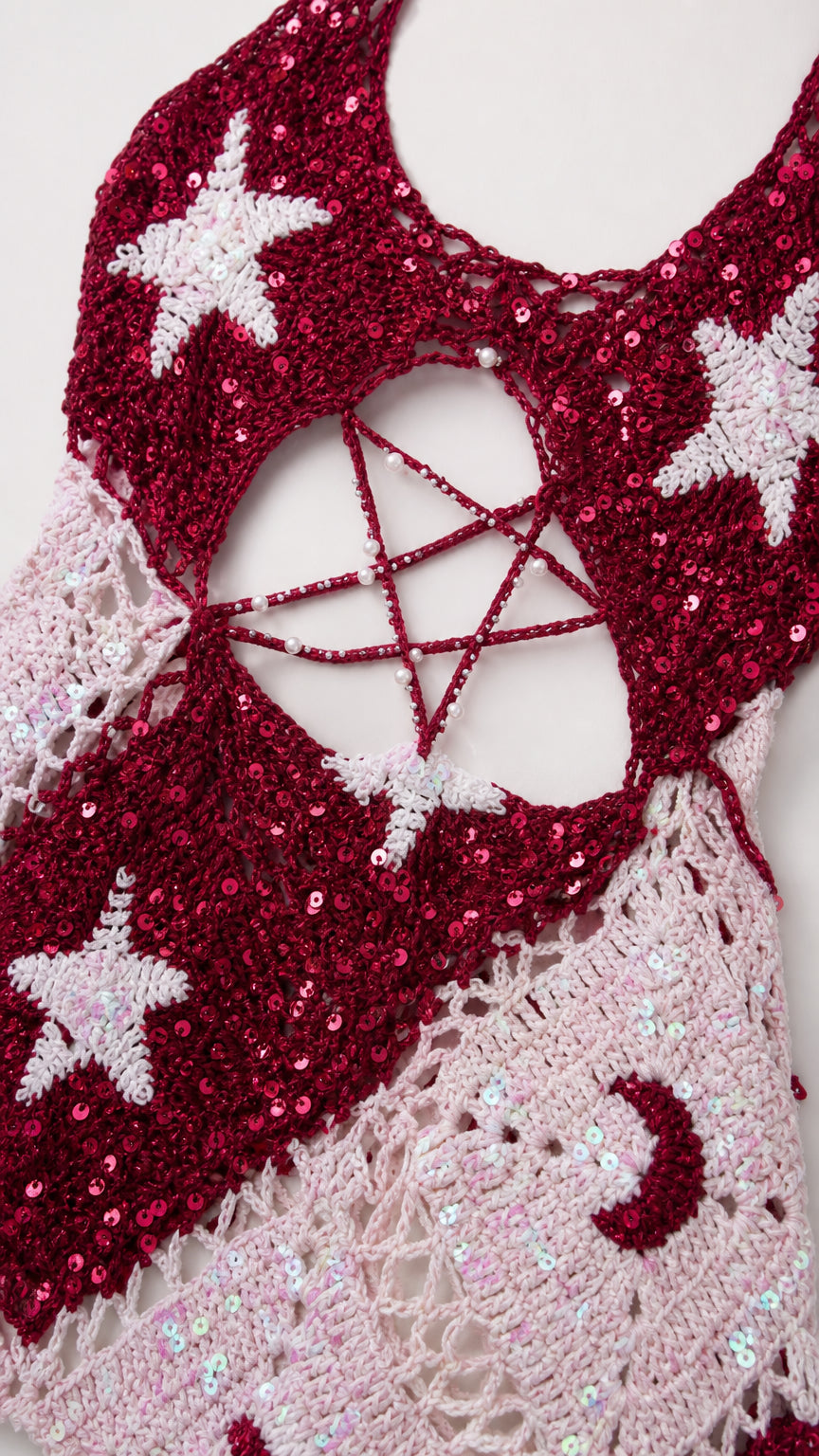 Close-up detail of sequin embroidery, openwork crochet knit, and star motifs
