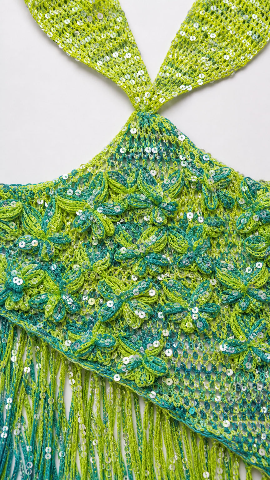 Close-up detail of lime green sequin crochet knit texture and fringe hem