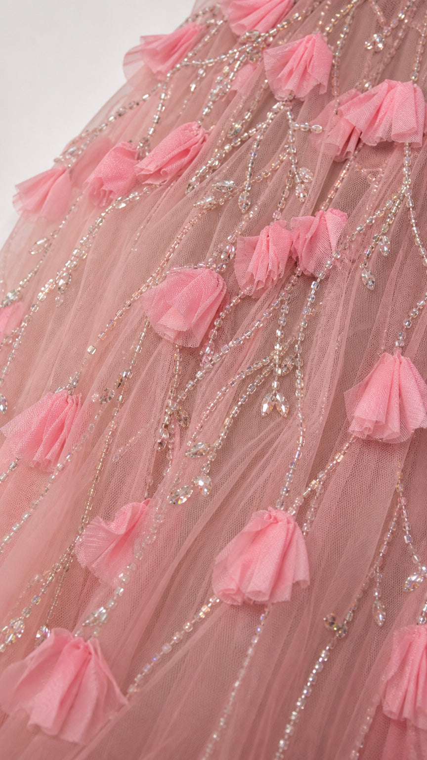 Close up of 3D pink floral petal appliqués and sequin beadwork on tulle