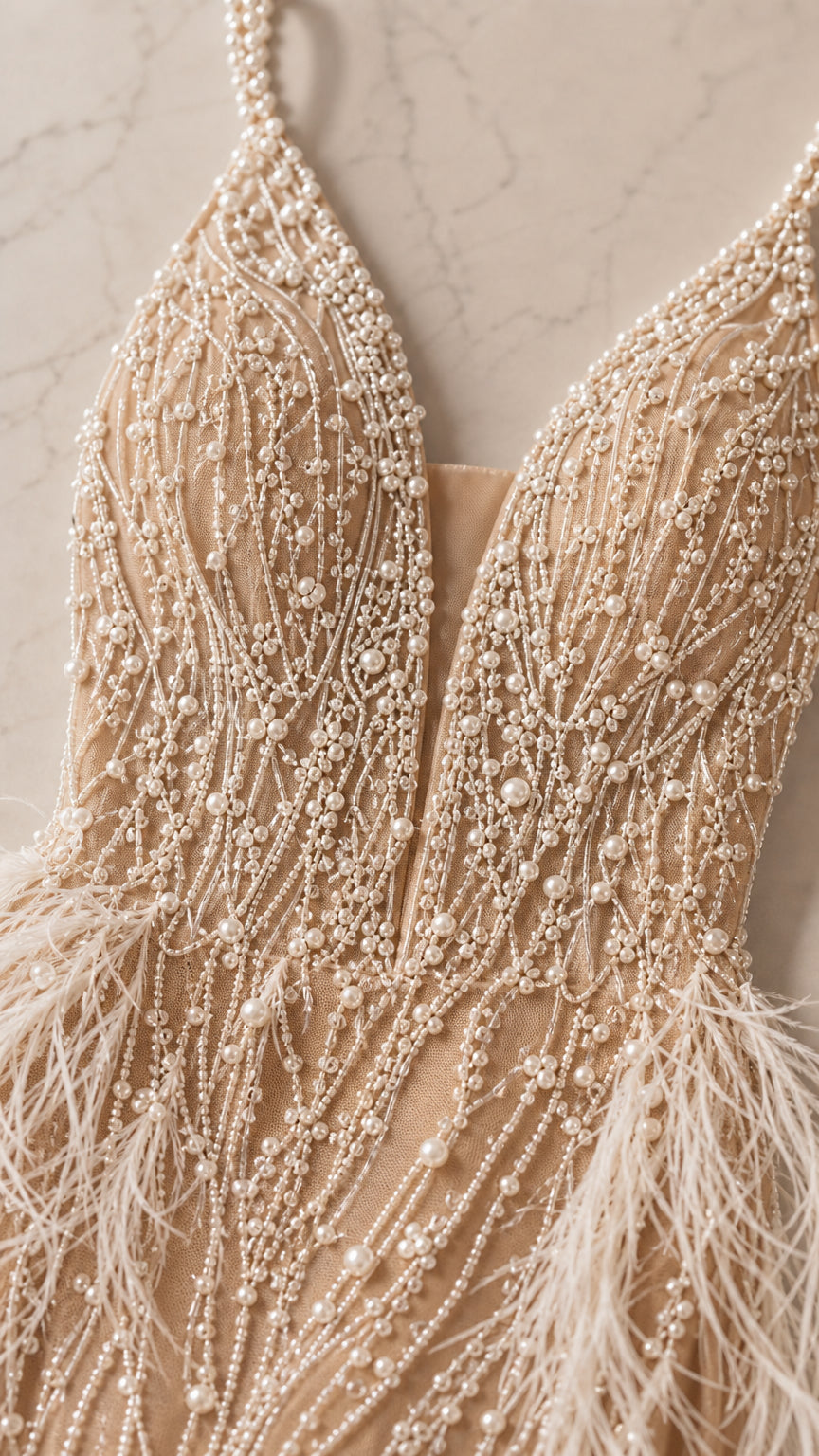 Close-up detail of champagne beaded pearl embroidery and feather trim