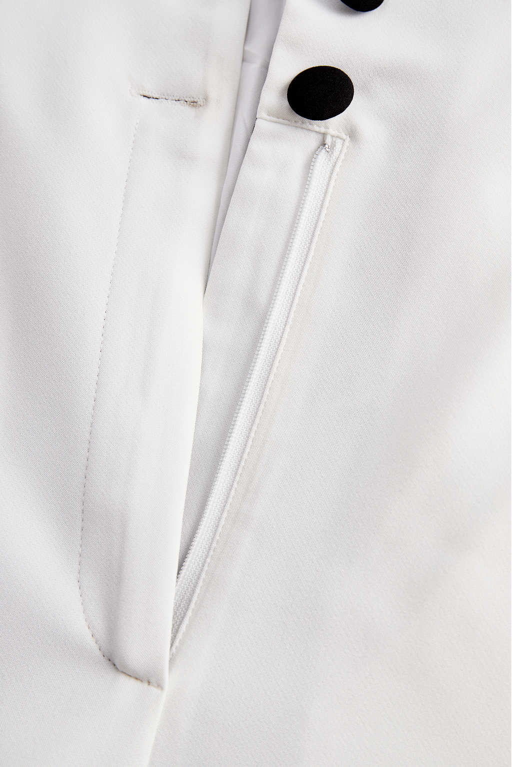 Sleek White Jumpsuit With Dual Button Detail And Black Lapel